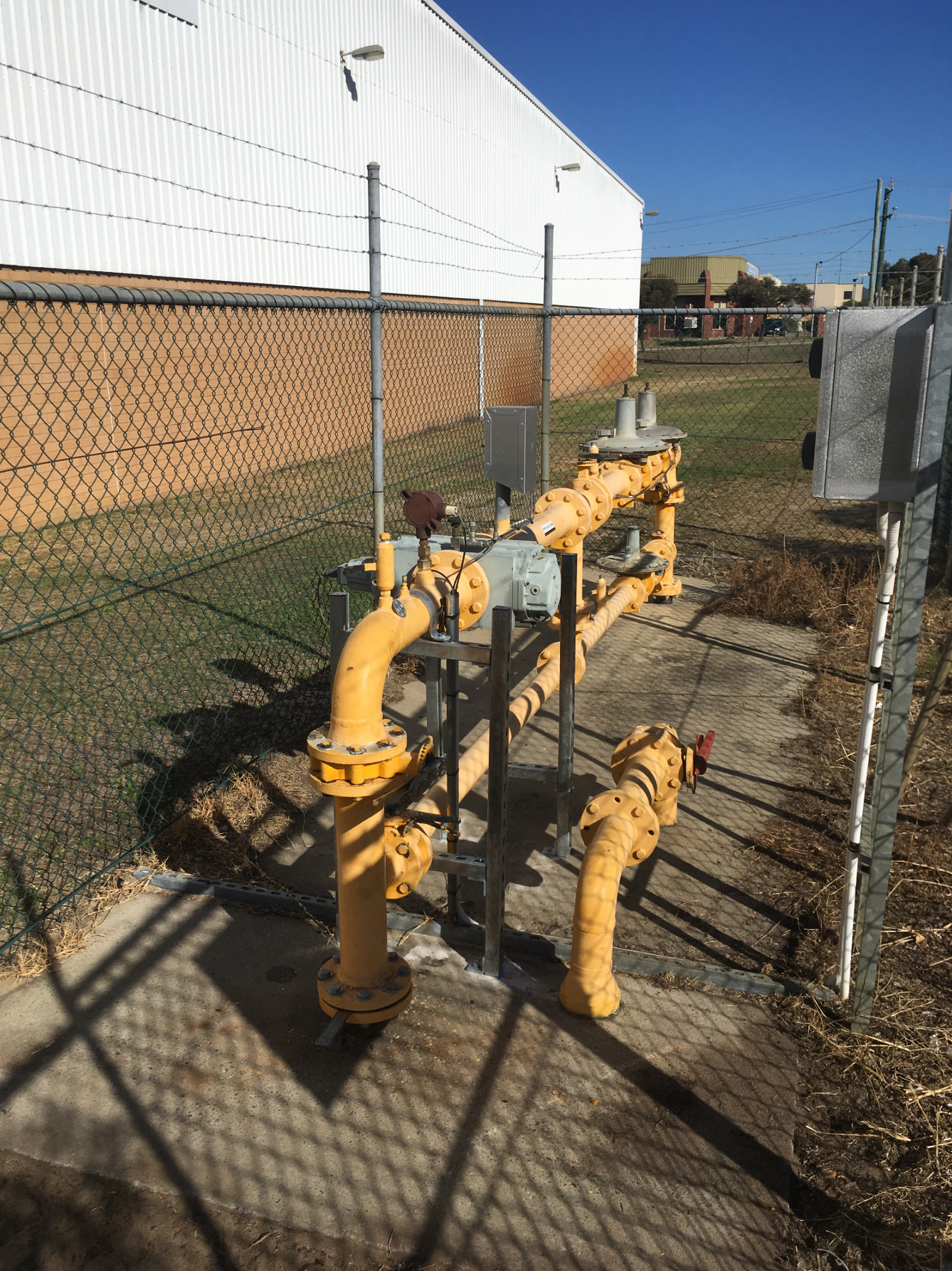 Natural gas service with meter, filter and regulators on a fenced site pad.